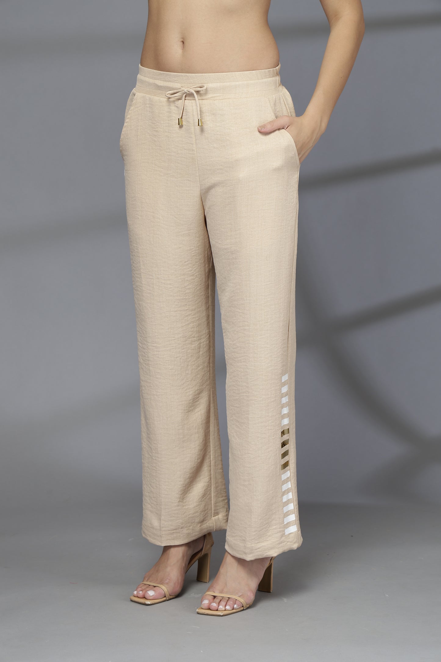 Beige pants worn by a person on a gray background
