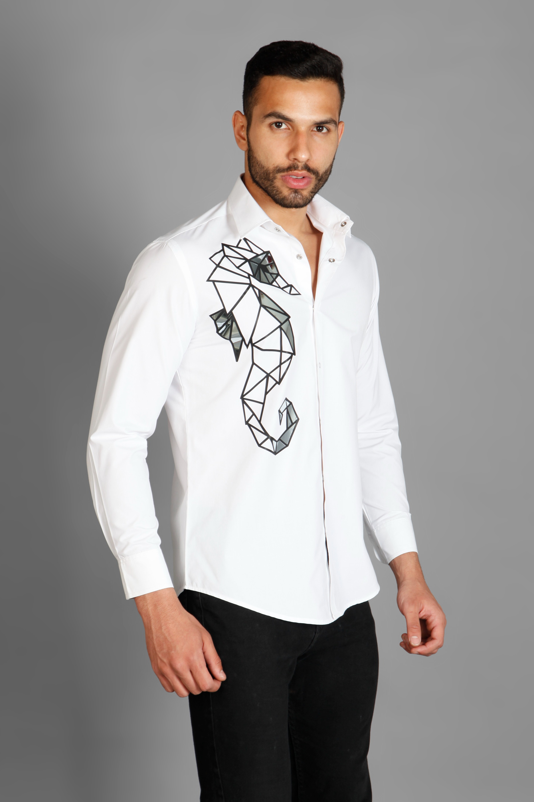 A white crisp cotton men's shirt with abstract big sea horse print detailed with metallic silver highlights on the print. The shirt is handcrafted for a regular fit style. Shop statement looks at Just Billi. 