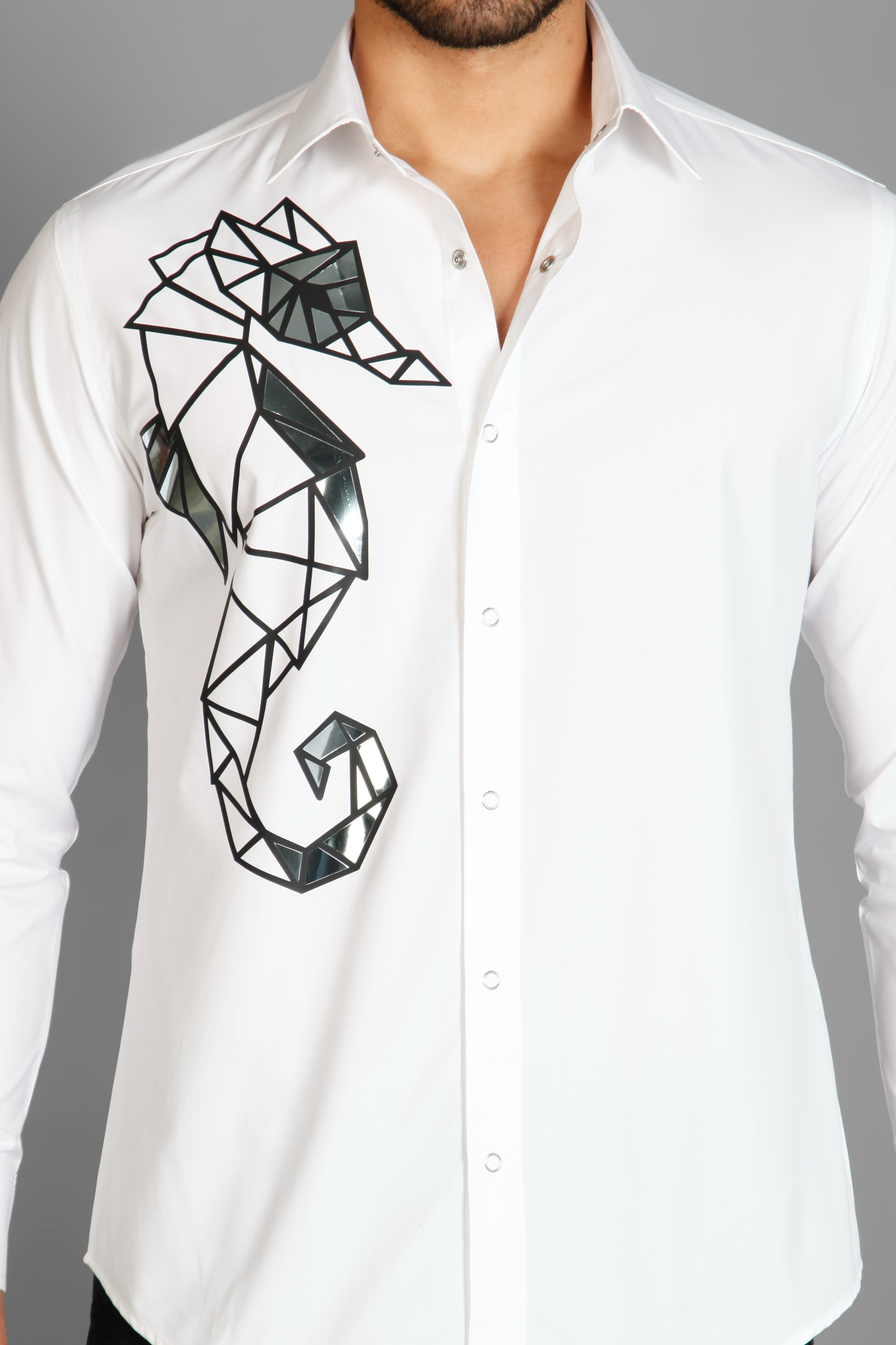 A white crisp cotton men's shirt with abstract big sea horse print detailed with metallic silver highlights on the print. The shirt is handcrafted for a regular fit style. Shop statement looks at Just Billi. 