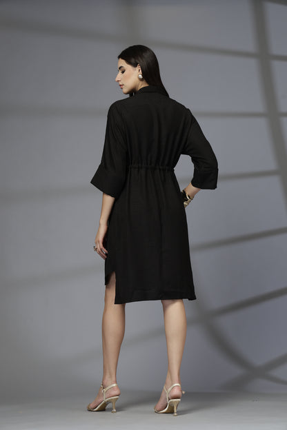Woman wearing a black dress against a gray background