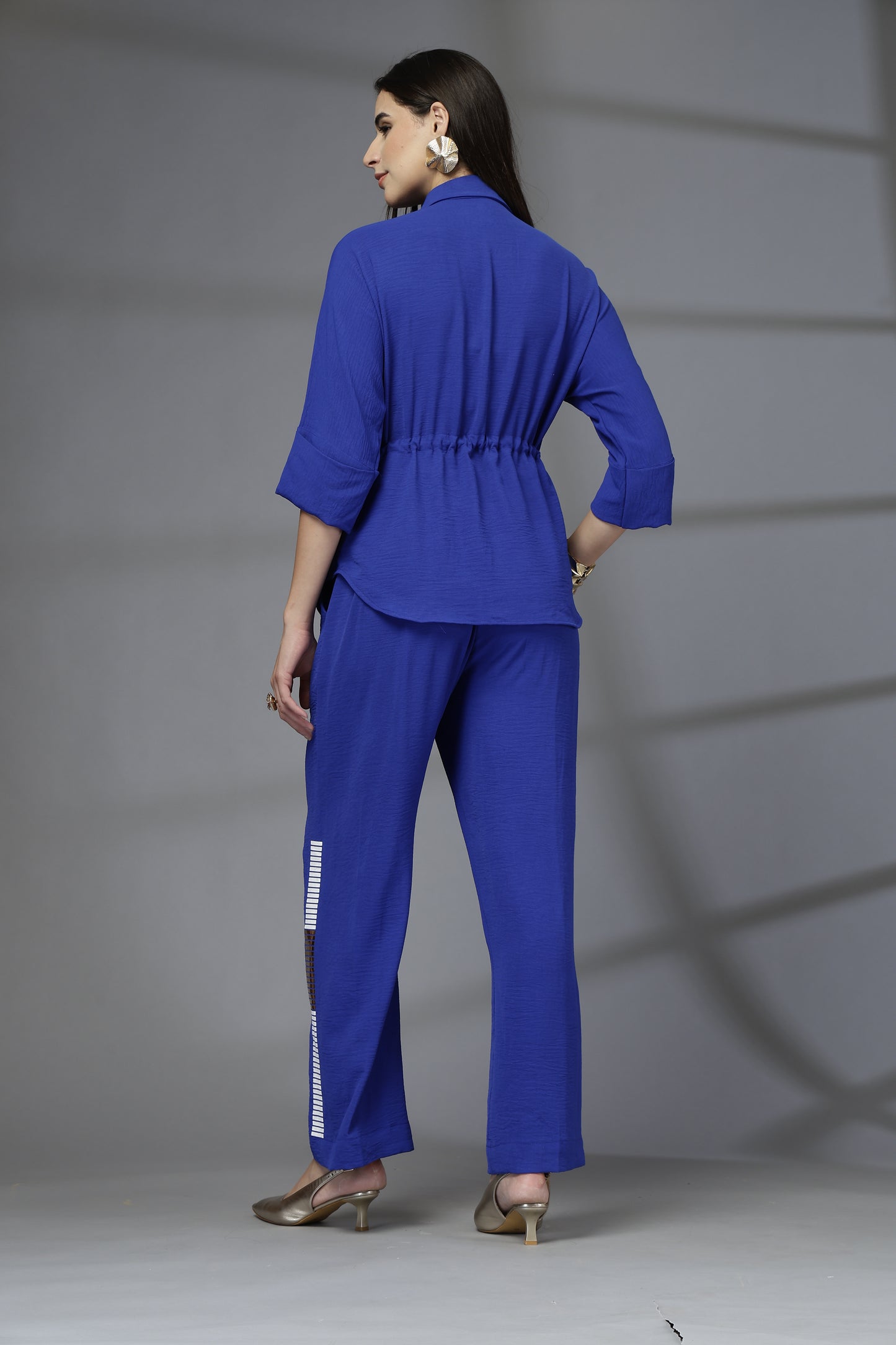 Woman wearing a blue outfit with a gray background