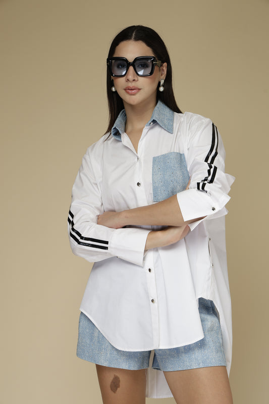 Woman wearing a white jacket with blue accents and sunglasses on a beige background