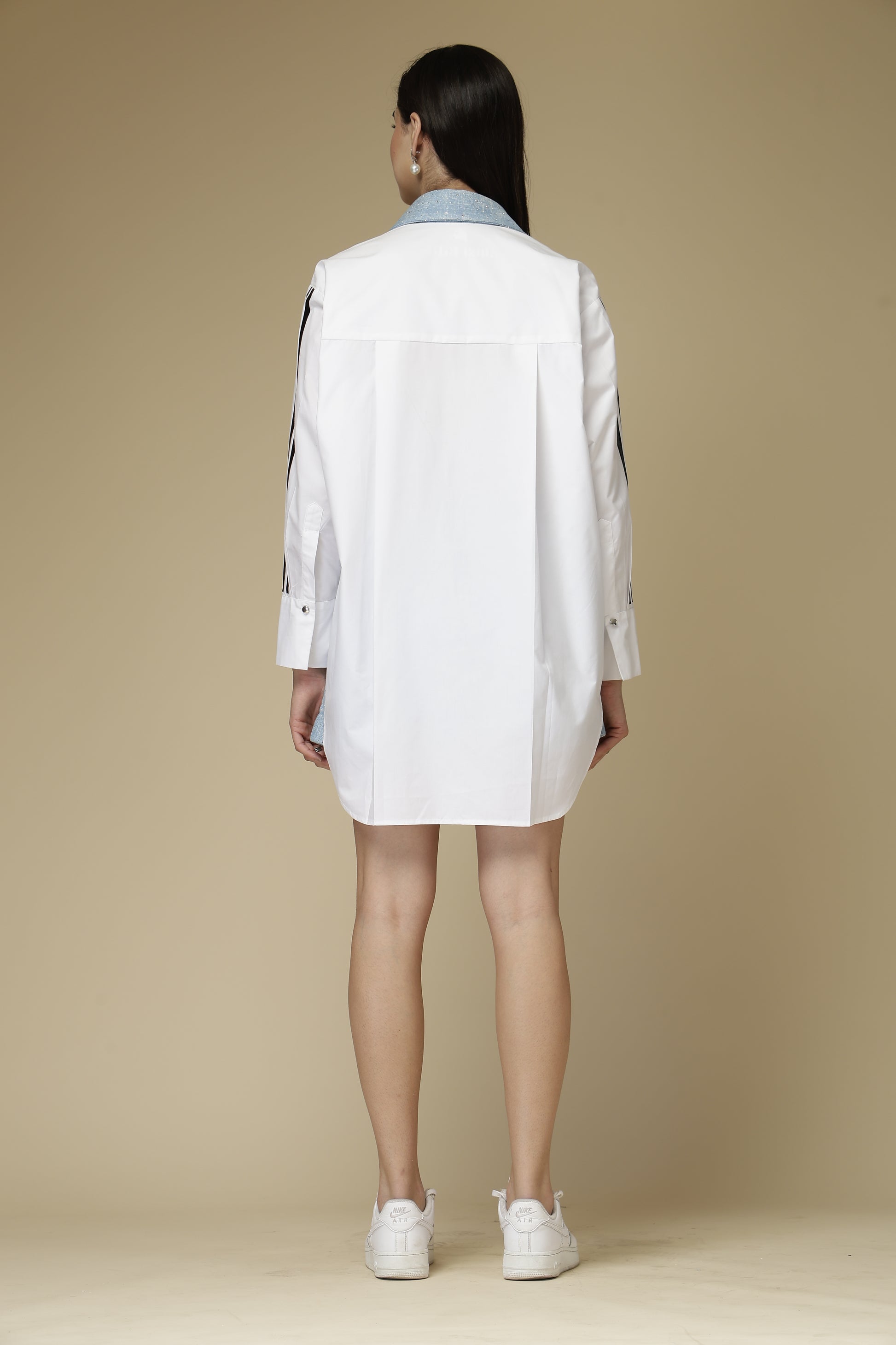 Person wearing a white lab coat on a beige background