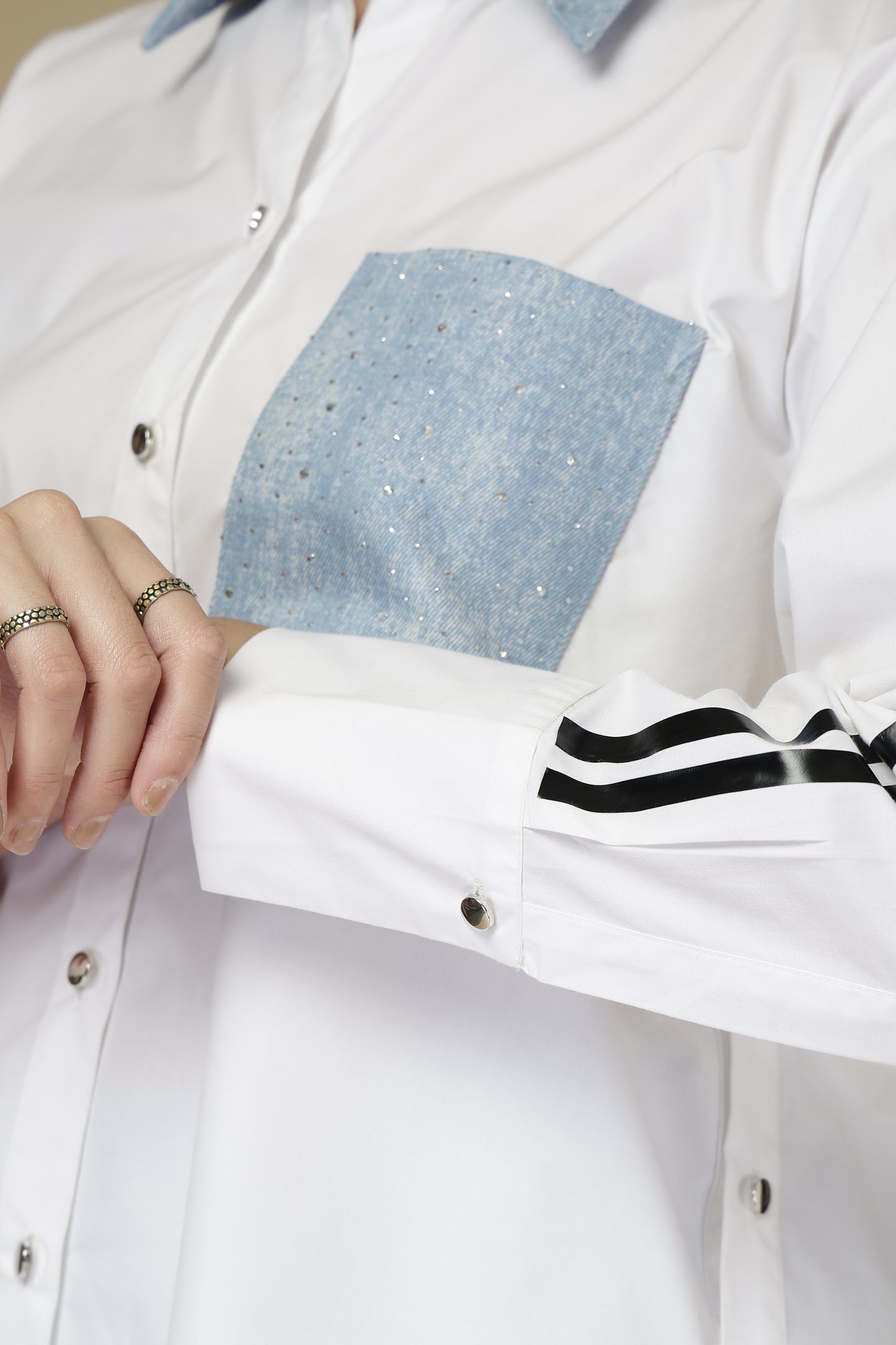 White shirt with blue patch and black stripes on sleeves