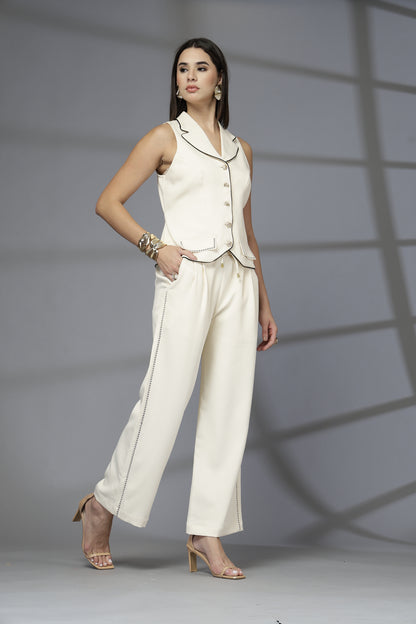Woman in a white outfit standing against a gray background