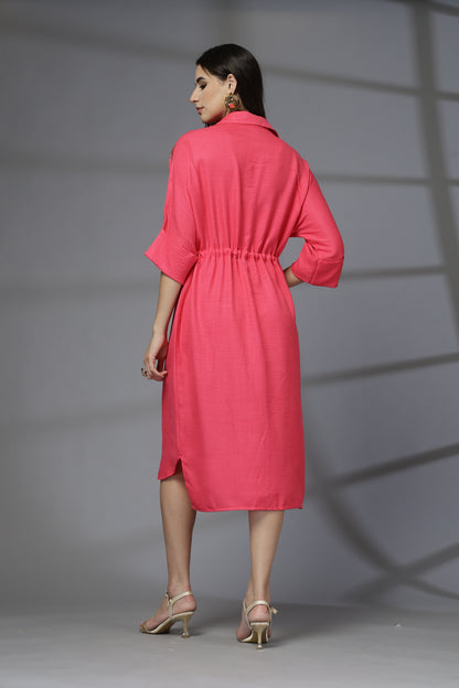 Woman wearing a pink dress against a gray background