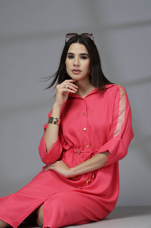 Woman wearing a pink dress sitting on a gray background