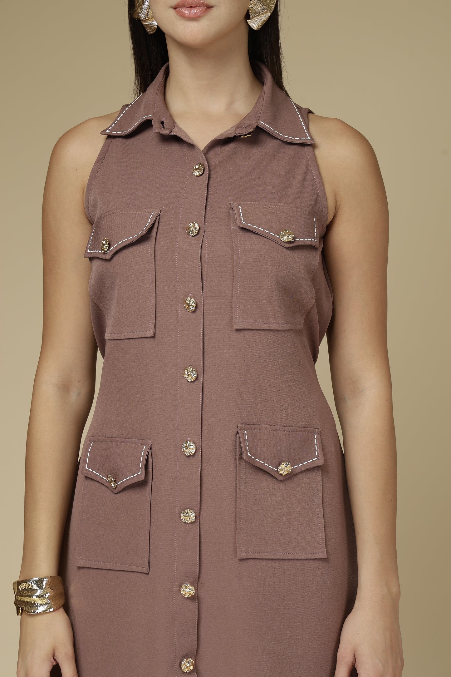 Brown sleeveless dress with button details on a beige background