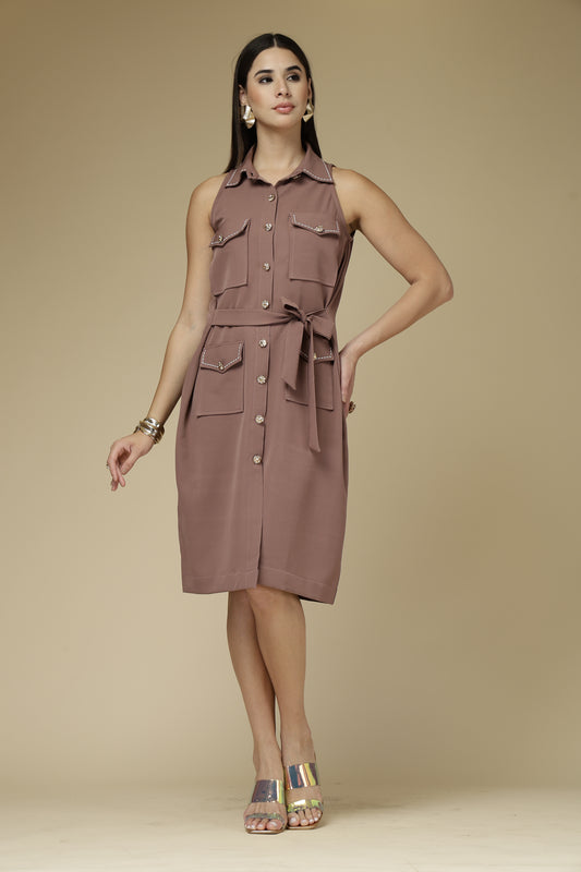 Woman wearing a sleeveless brown dress with pockets on a beige background