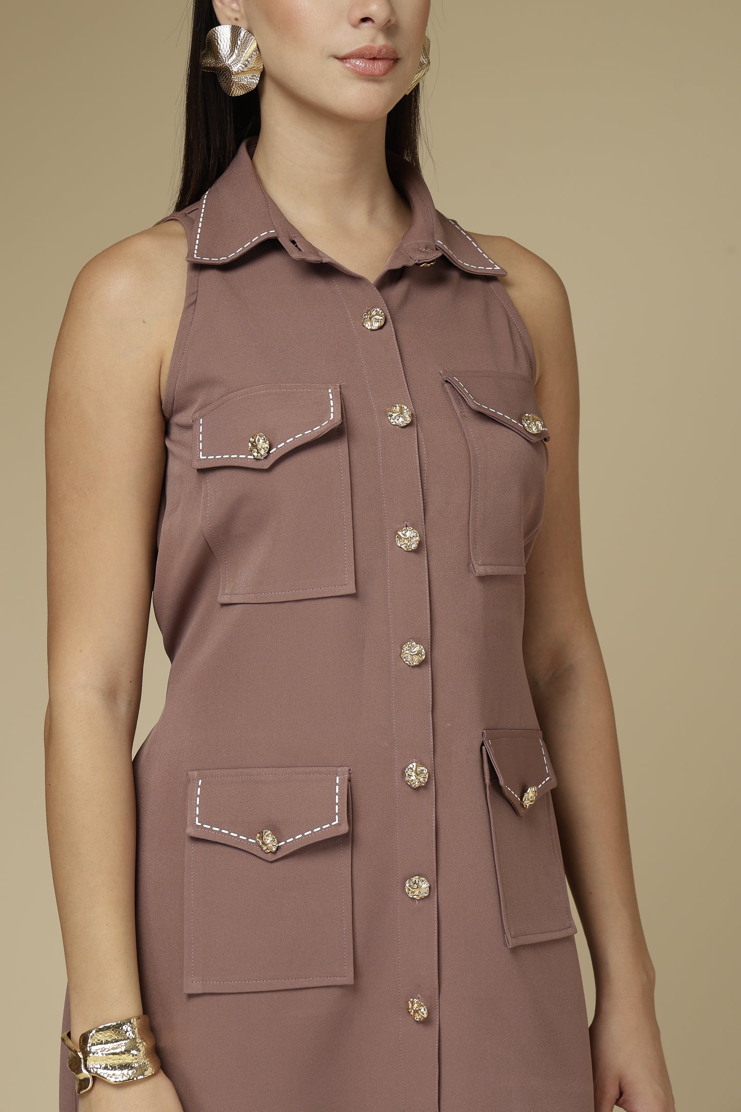 Brown sleeveless dress with button details on a beige background